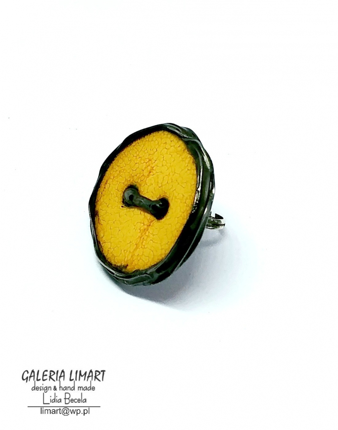pierścień stworzony z ręcznie wypalanego ceramicznego guzika w ciepło-żółto-złotawym ubarwieniu